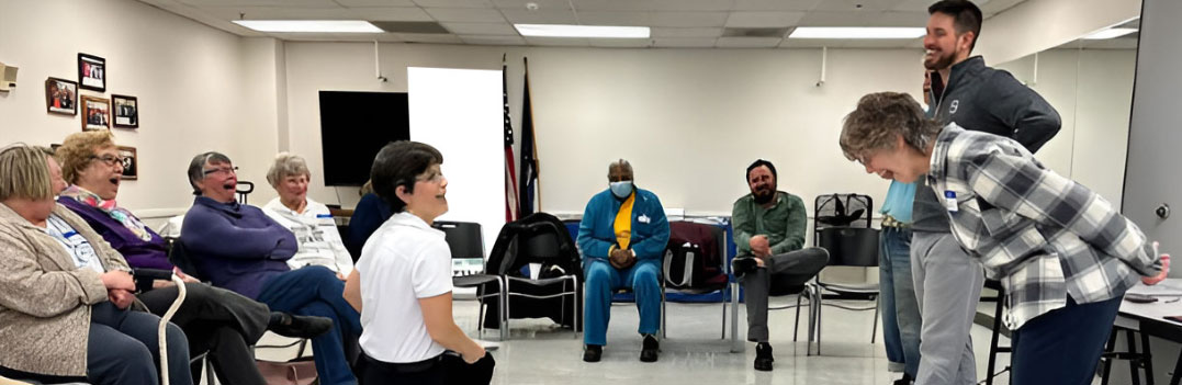 Seniors laughing together while playing senior improv games.